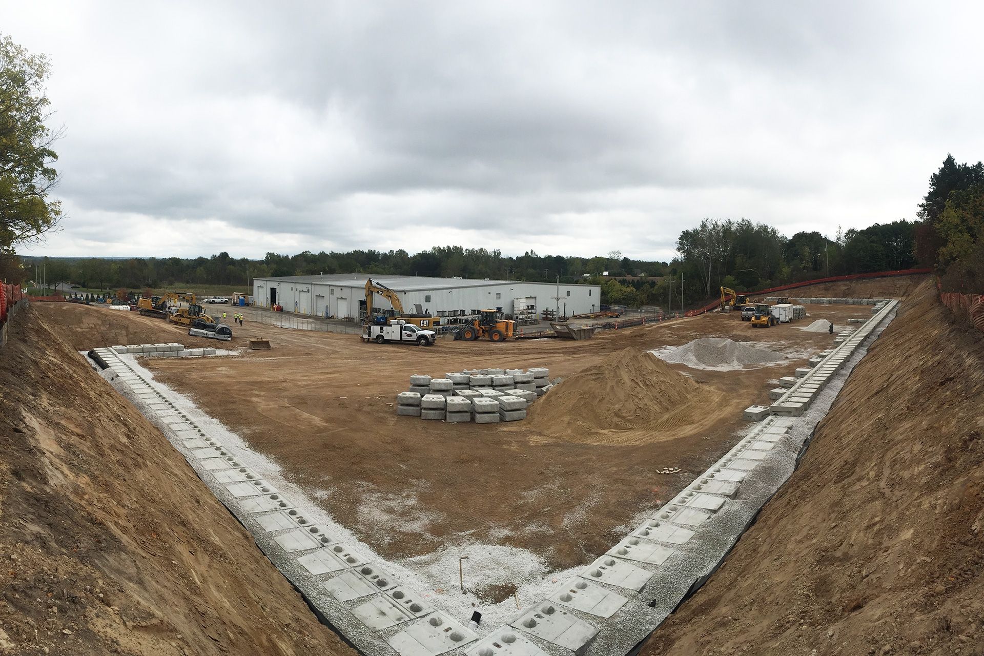 A large building is being built in the middle of a dirt field.