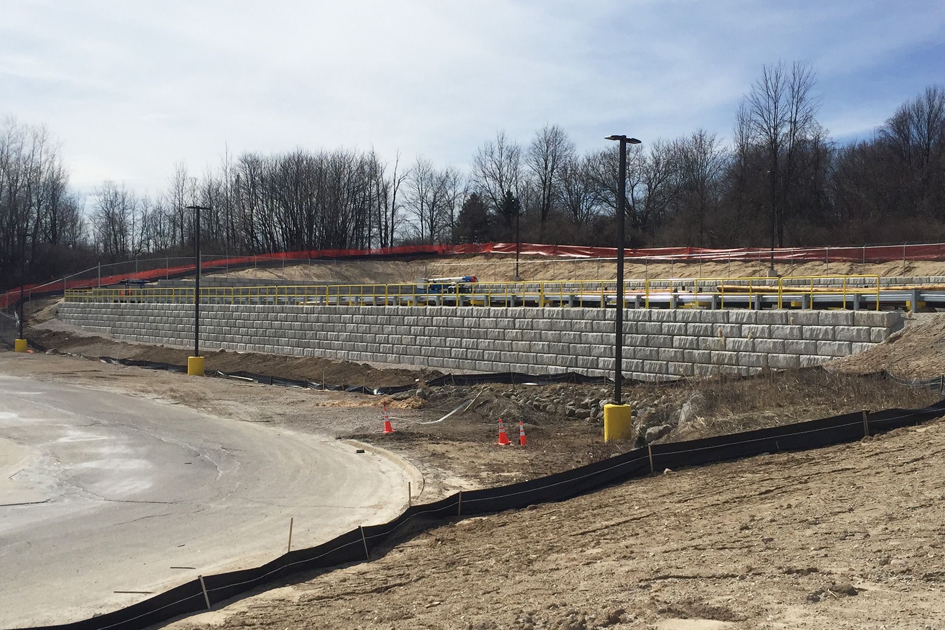 A large brick wall is being built in the middle of a dirt field.