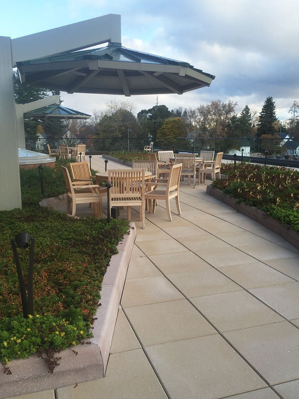 A patio with tables and chairs under an umbrella