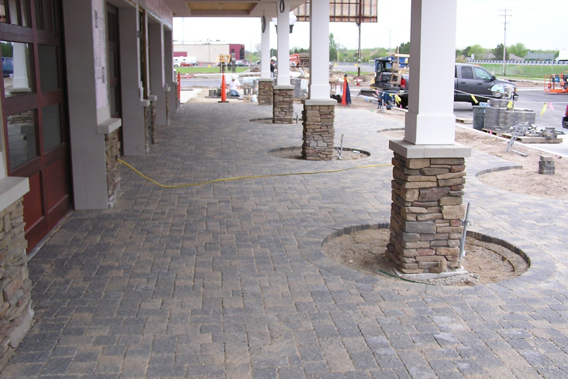 A brick walkway with pillars in the middle of it