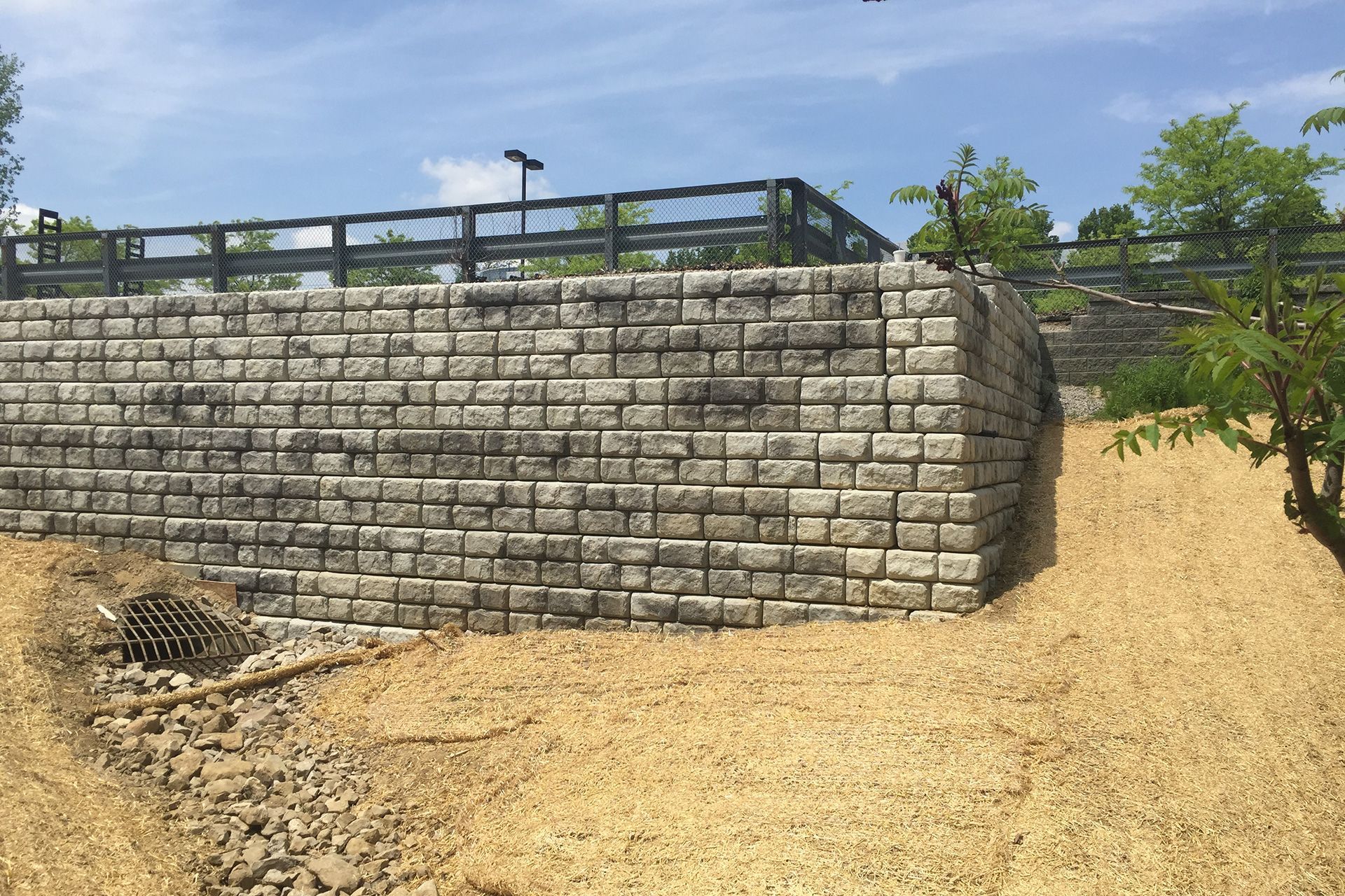 A large brick wall is sitting on top of a dirt hill.