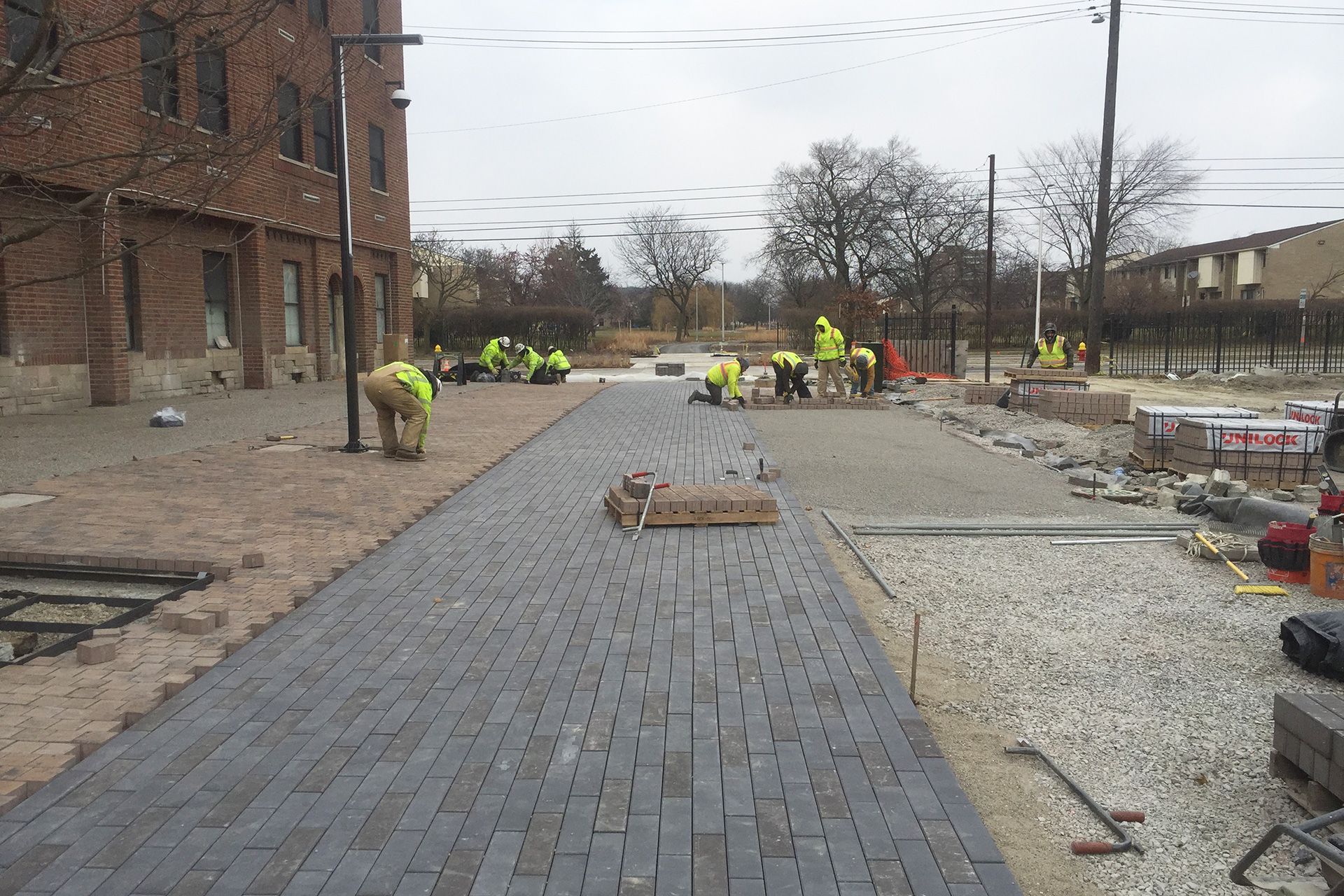 A group of construction workers are working on a sidewalk