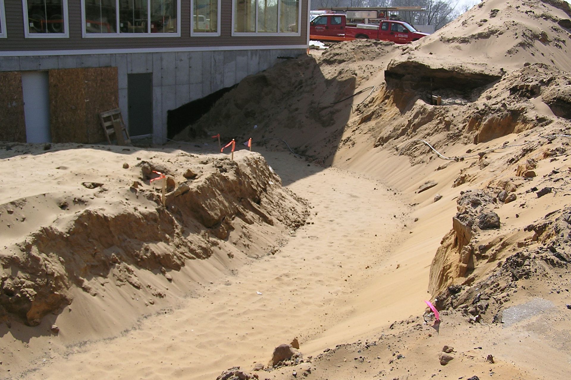 A large pile of sand is in front of a building