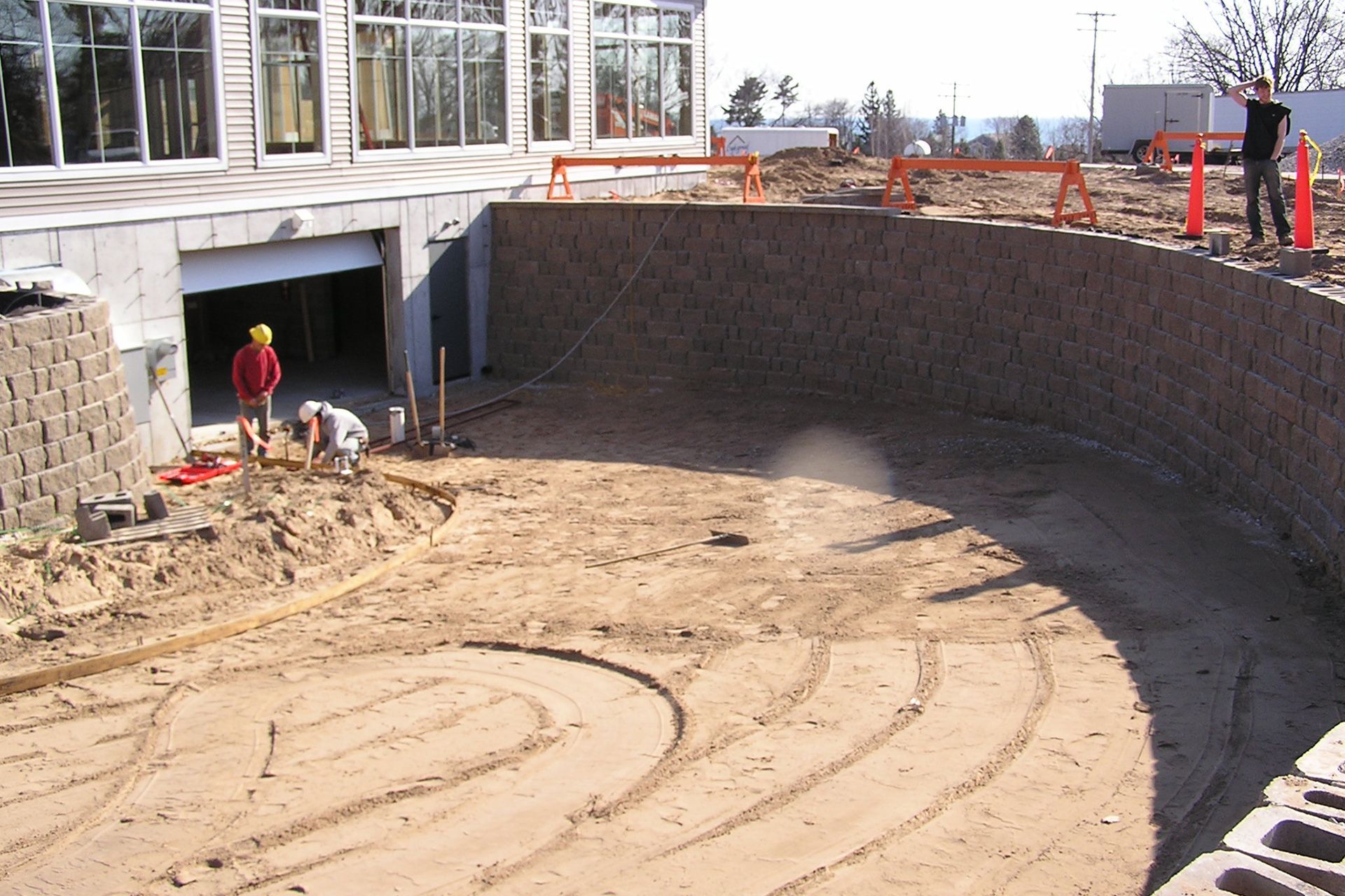 A group of construction workers are working in the dirt in front of a building