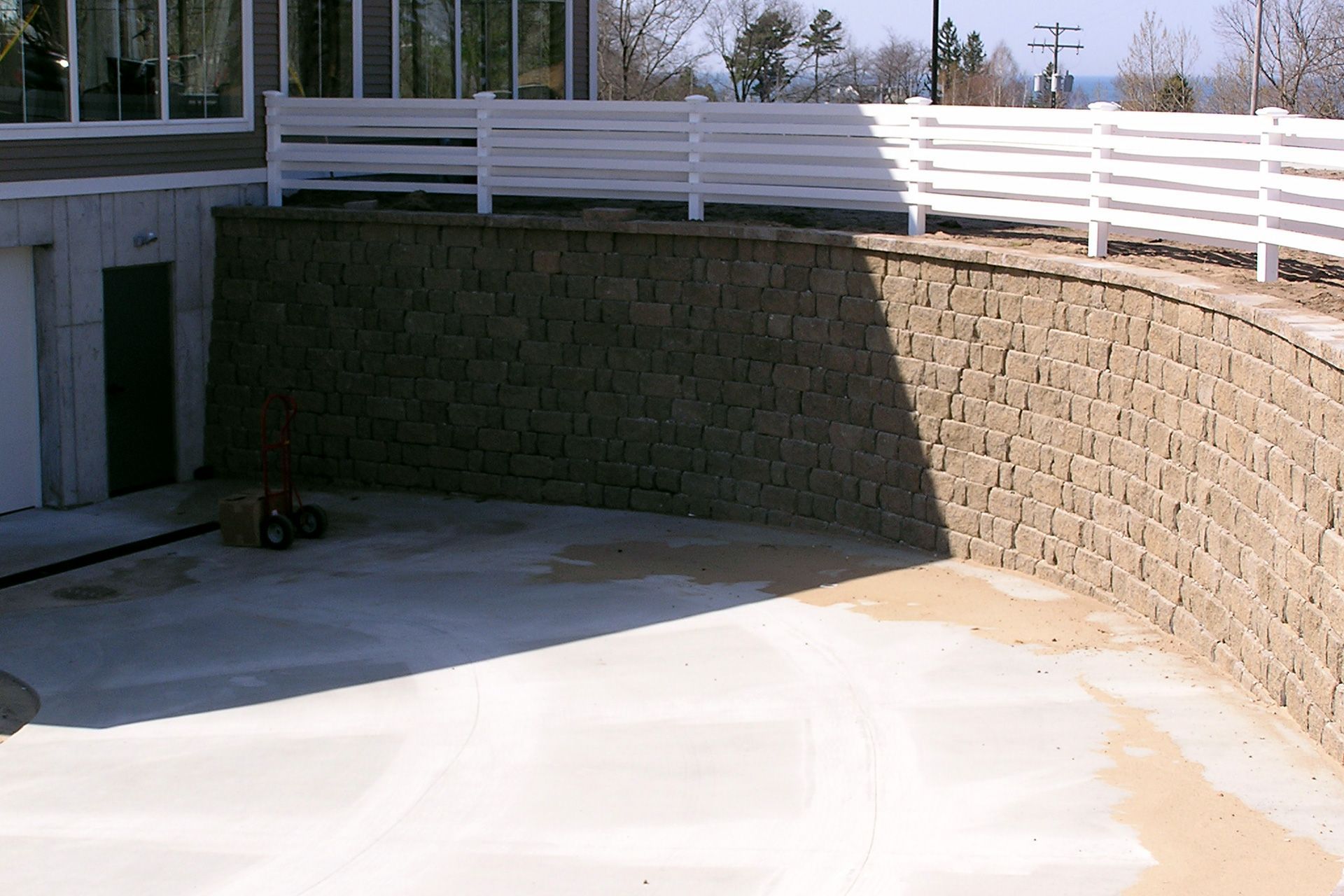 A brick wall with a white fence surrounding it