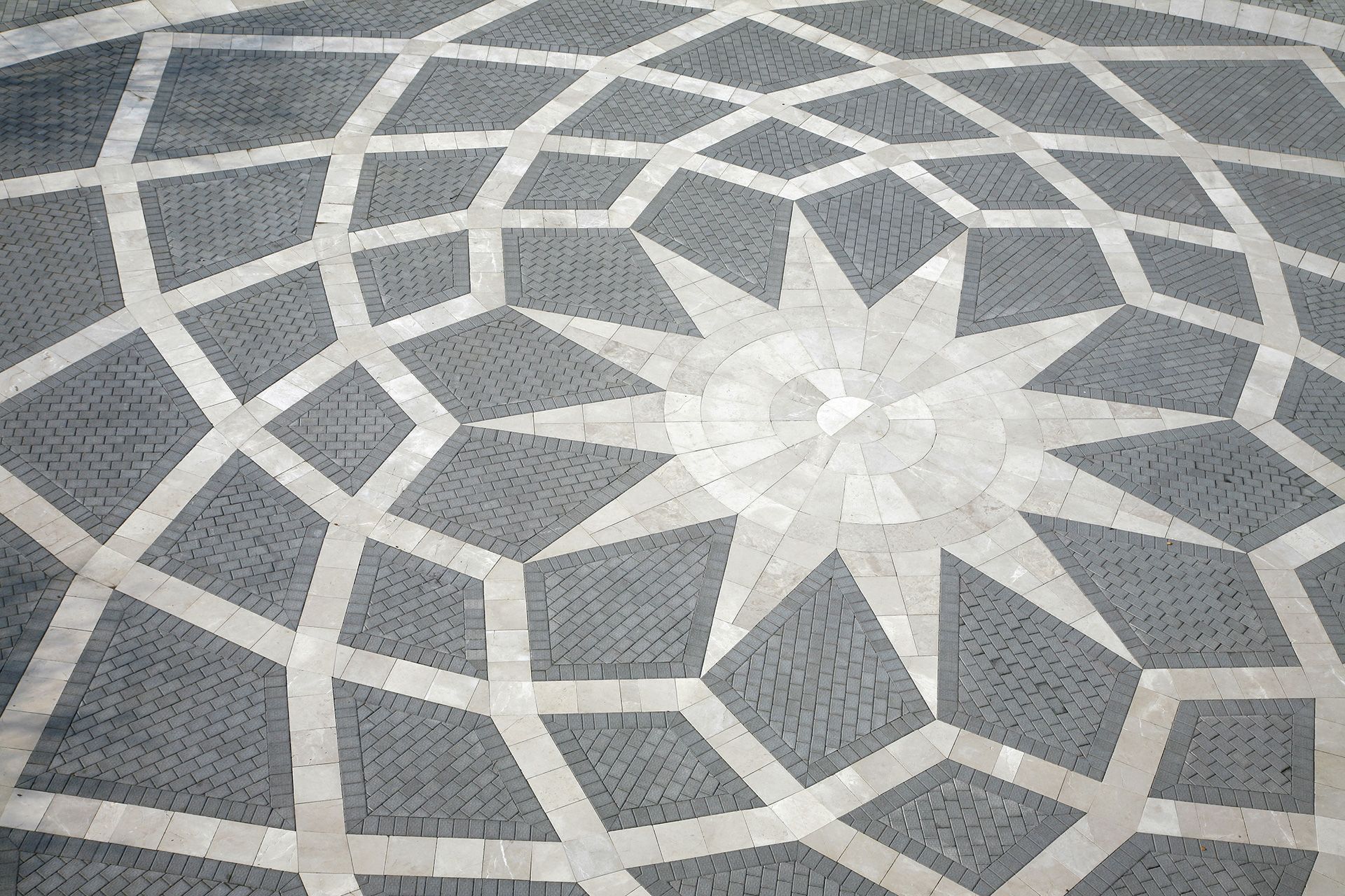 A circular pattern on a brick floor with a star in the middle.