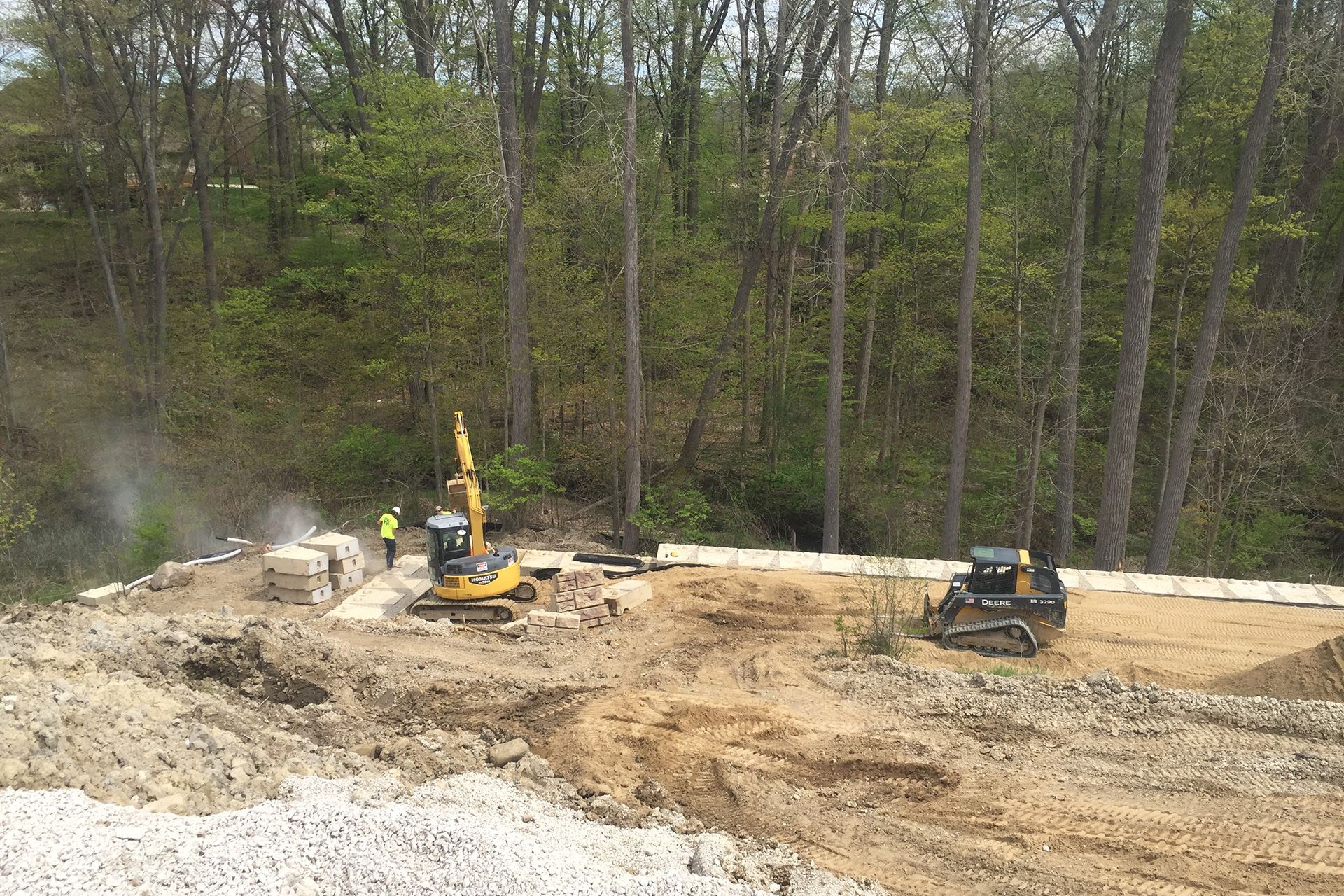 A construction site with a lot of dirt and trees in the background.