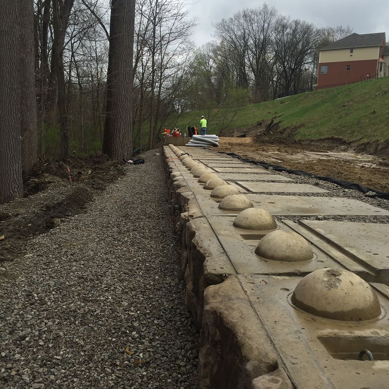 A row of concrete blocks are lined up on a gravel road