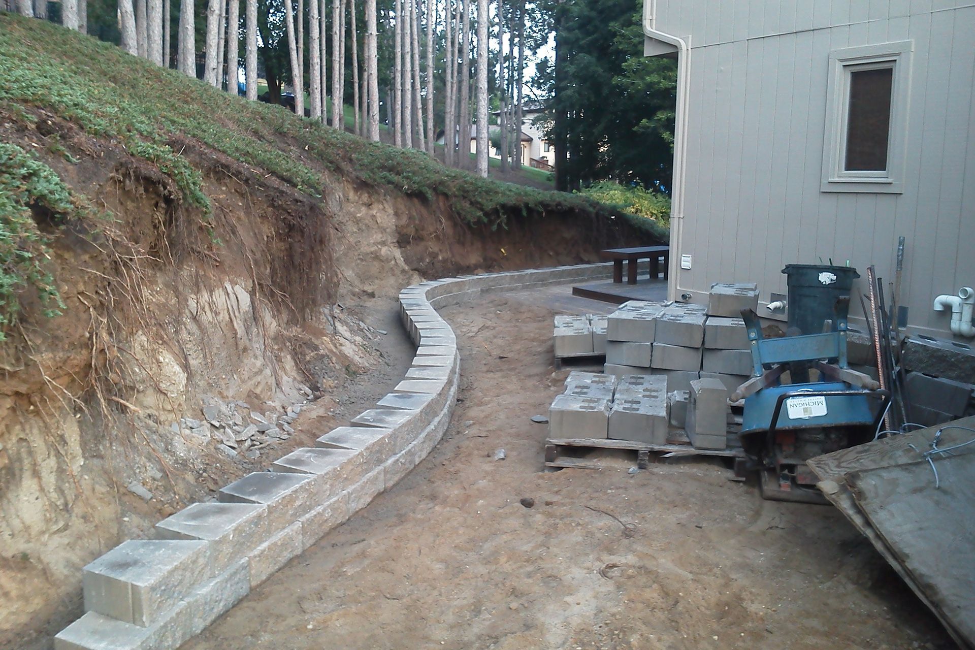 A concrete wall is being built in front of a house