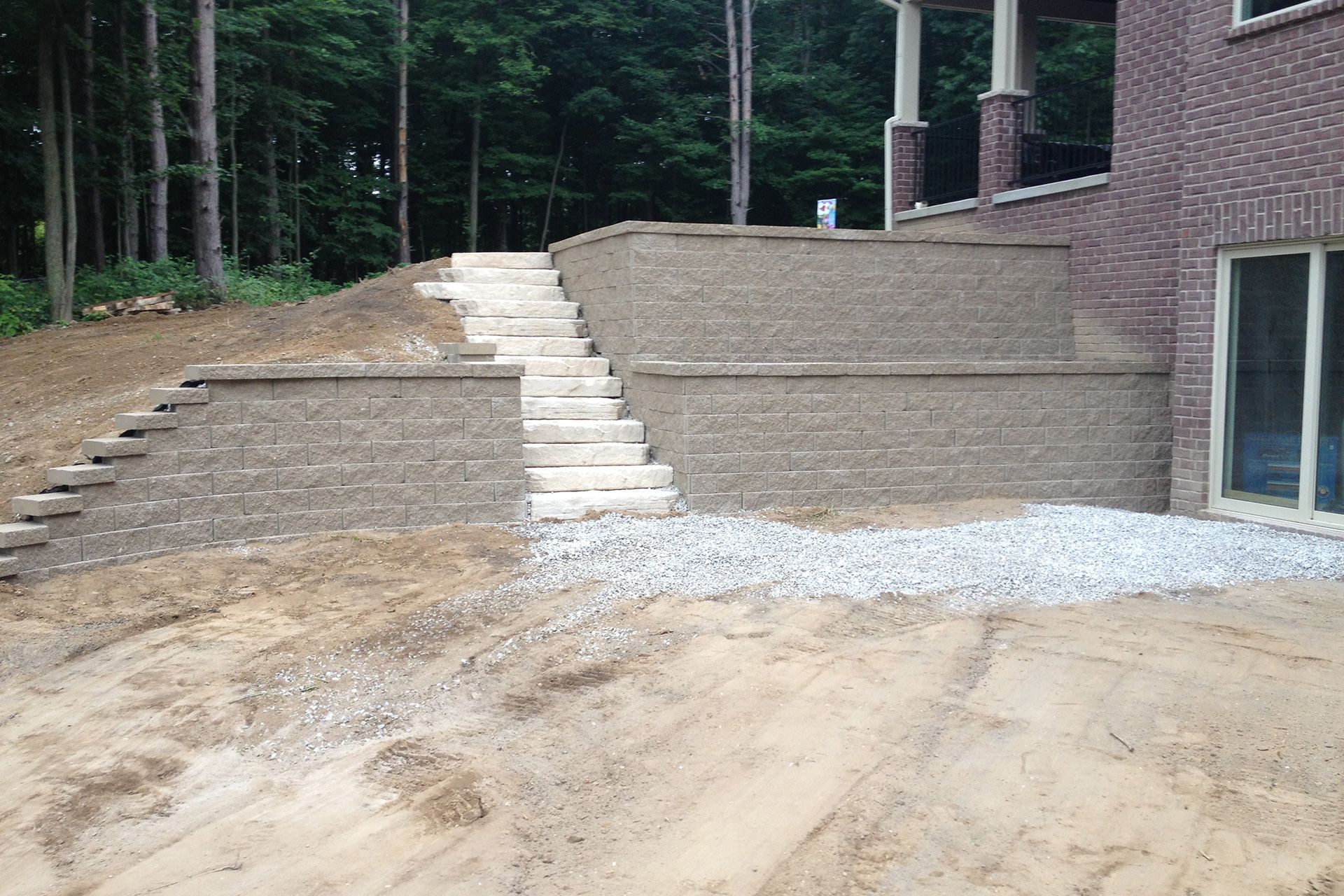 A brick wall with stairs leading up to a house