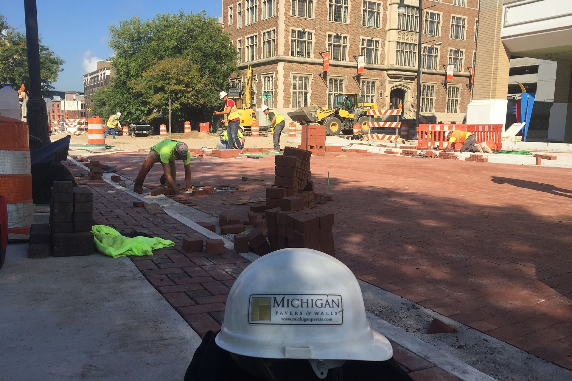 A white michigan hard hat sits on a brick sidewalk