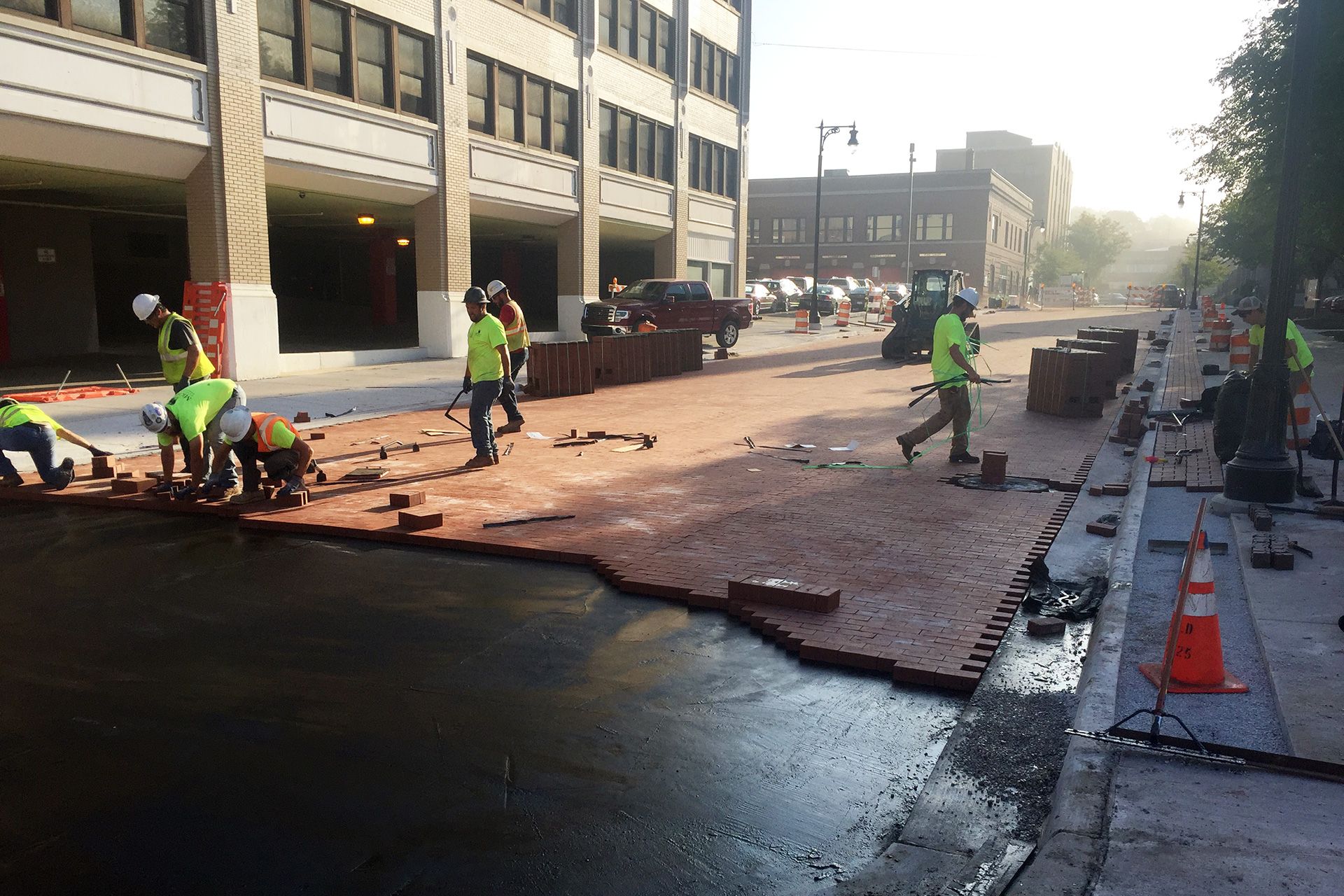 A group of construction workers are working on a sidewalk