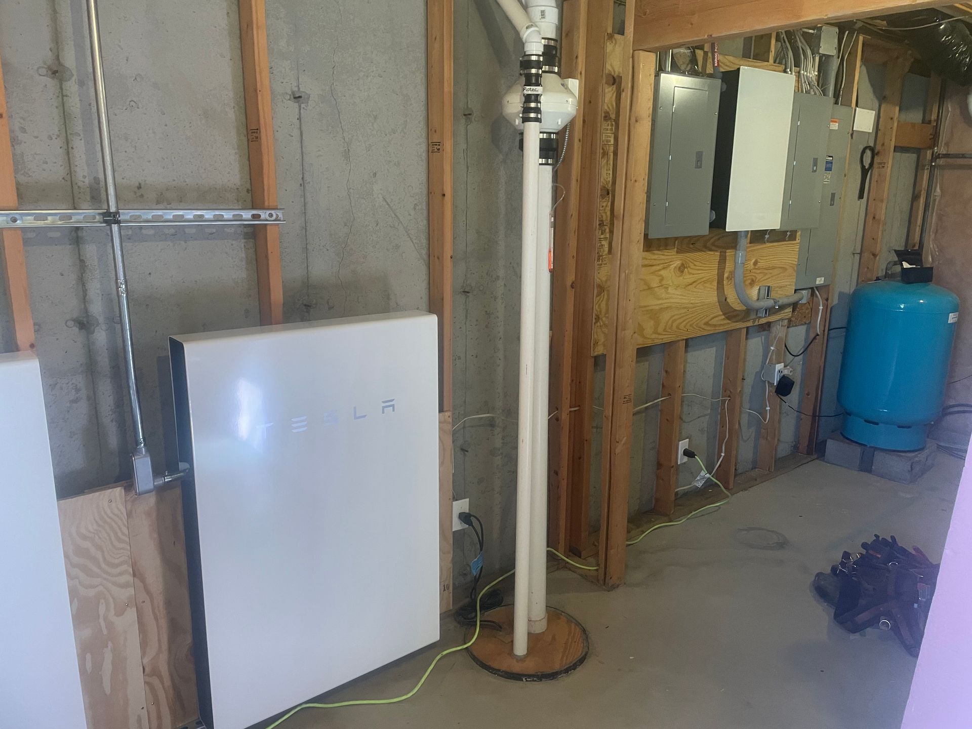 Person using a screwdriver to work on a white electrical outlet on a tiled wall.