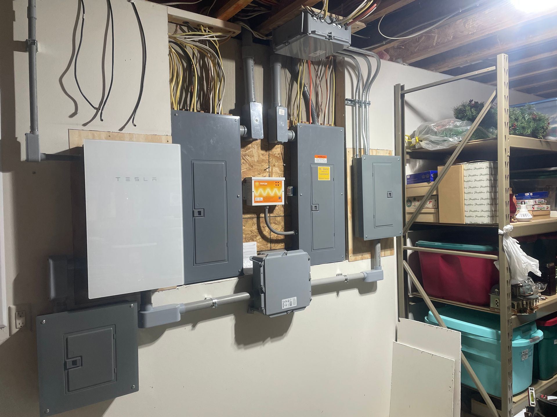Electrician working on a fuse box, wearing gloves and using a screwdriver.