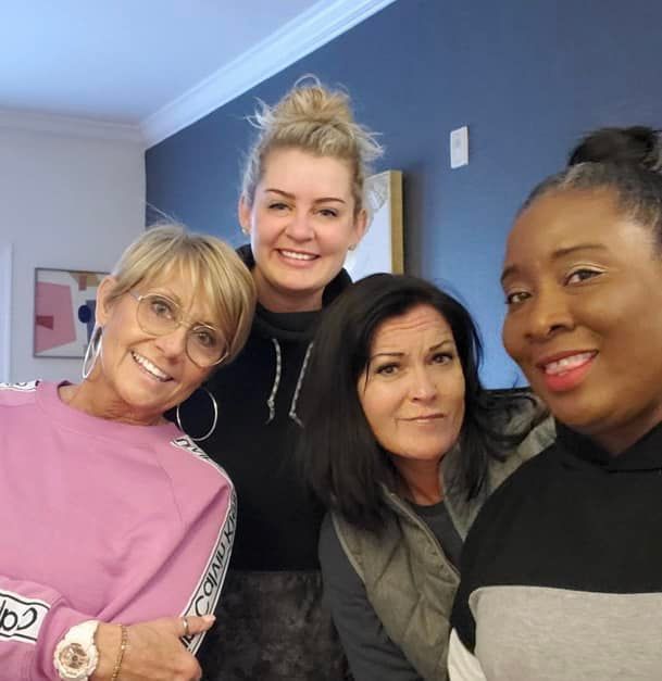 a group of women posing for a picture with one wearing a watch