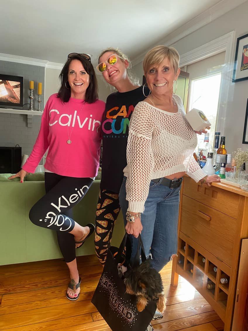 three women are standing next to each other in a living room .