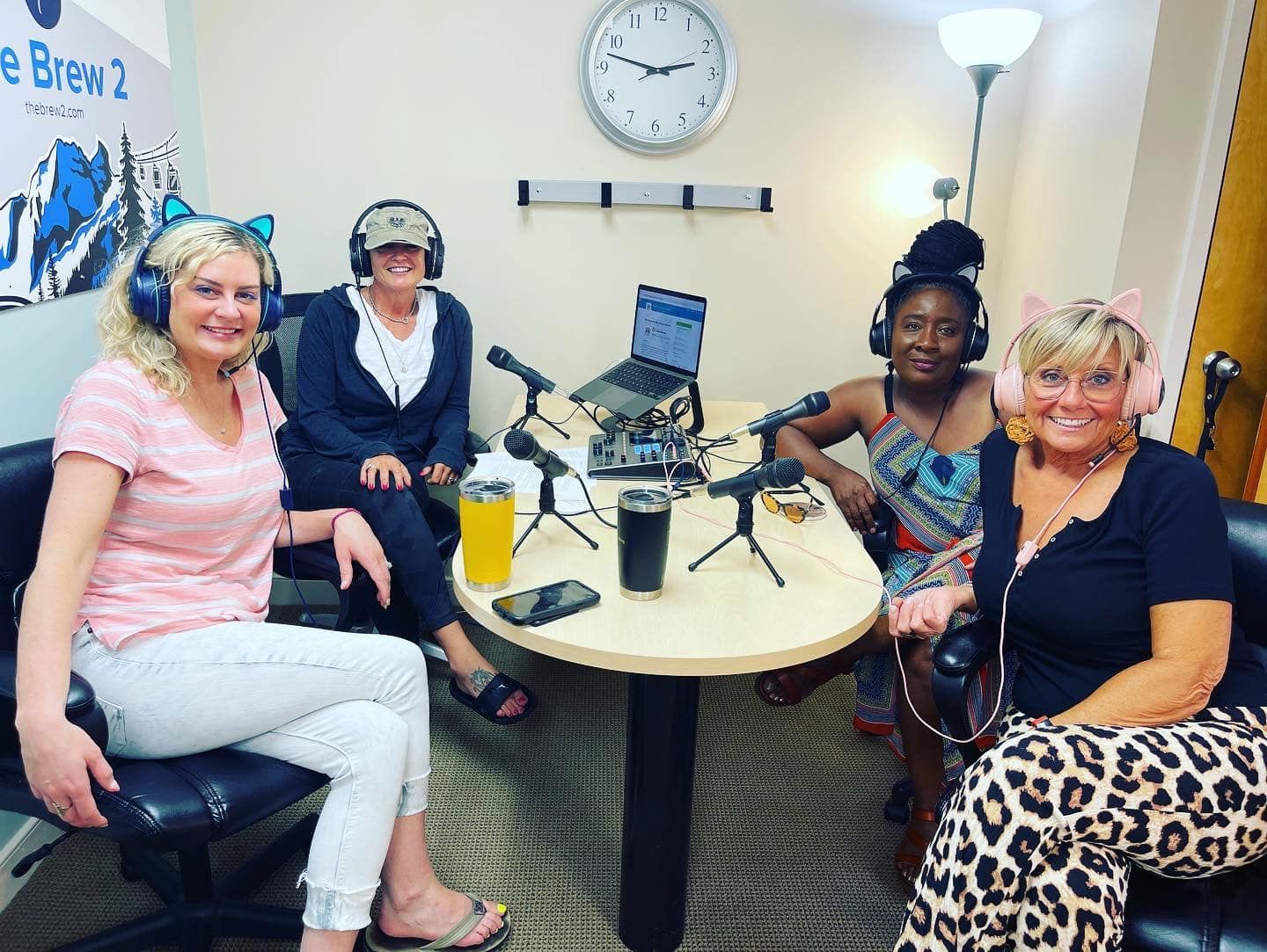 a group of women are standing around a table with drinks on it .
