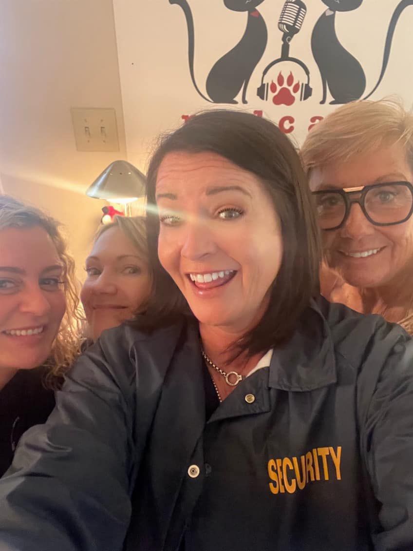 a group of people posing for a picture with one wearing a security jacket