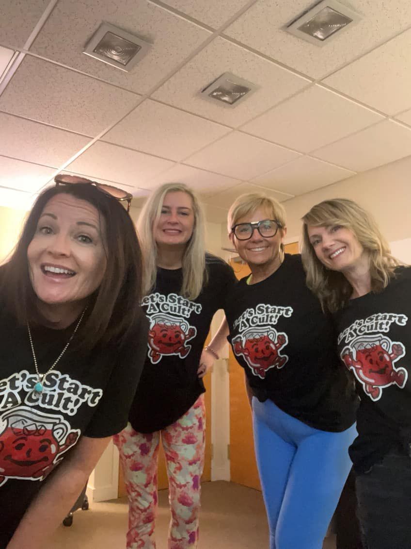 a group of women wearing k-cup t-shirts are posing for a picture .