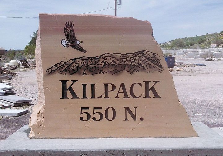 Black granite gravestone with a gold cross in a cemetery, on a rainy day
