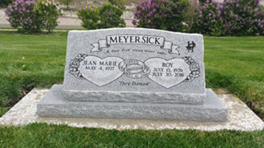 Gray granite double gravestone in a grassy cemetery, with MEYERSICK engraved at the top.