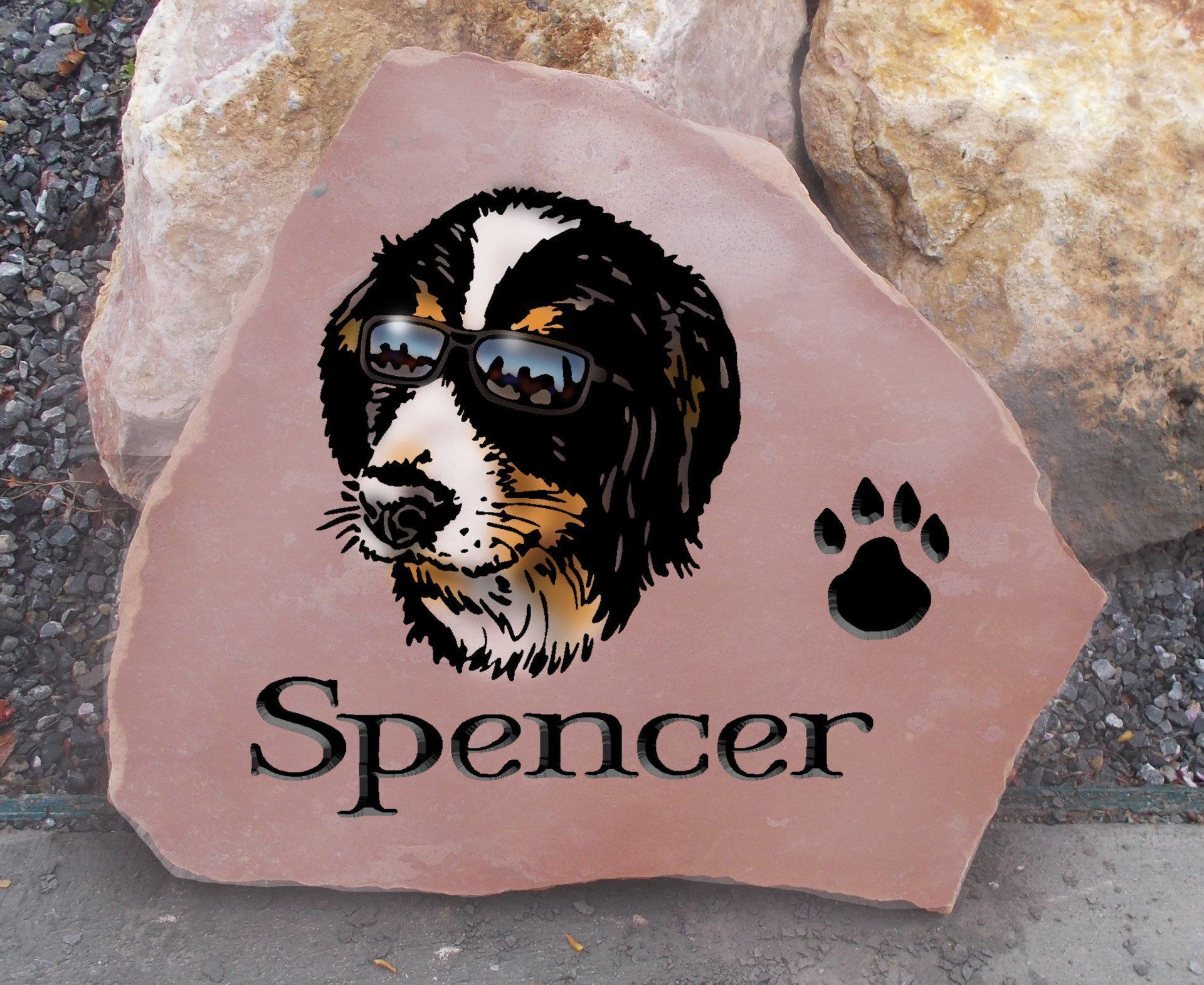 Pink memorial stone with dog portrait, paw print, and the name Spencer engraved on it.