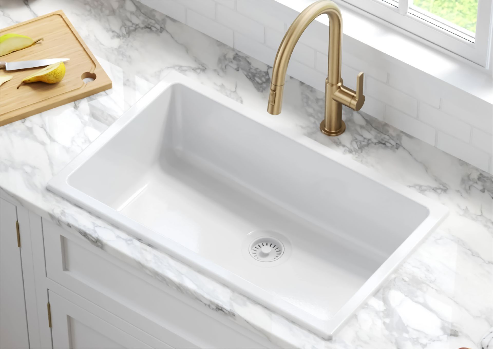 A white farmhouse sink with a gold faucet set into a white marble countertop.