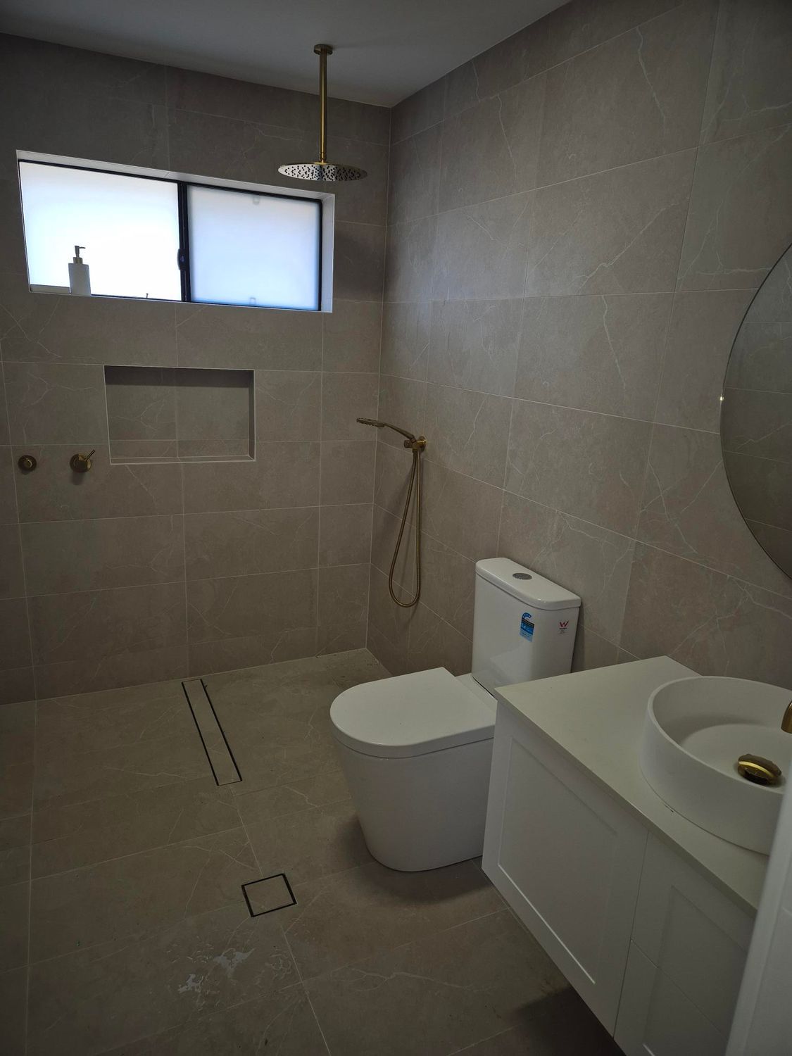 A Person Is Holding A Device In Front Of A Sink — Bennett Plumbing In Broughton Village, NSW