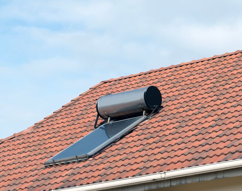 A Solar Water Heater Is Mounted On The Roof Of A House — Bennett Plumbing In Broughton Village, NSW