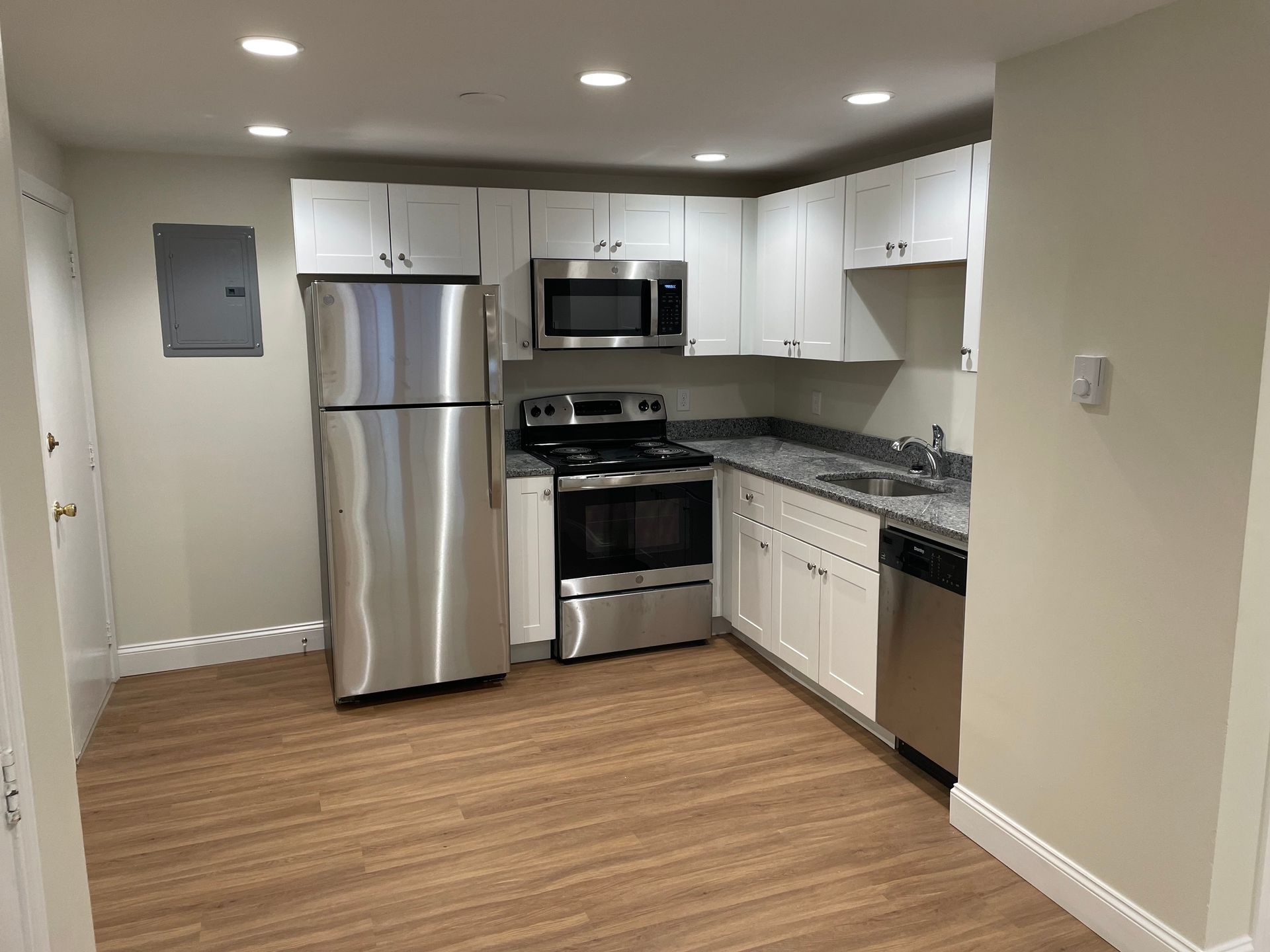 A kitchen with stainless steel appliances and white cabinets