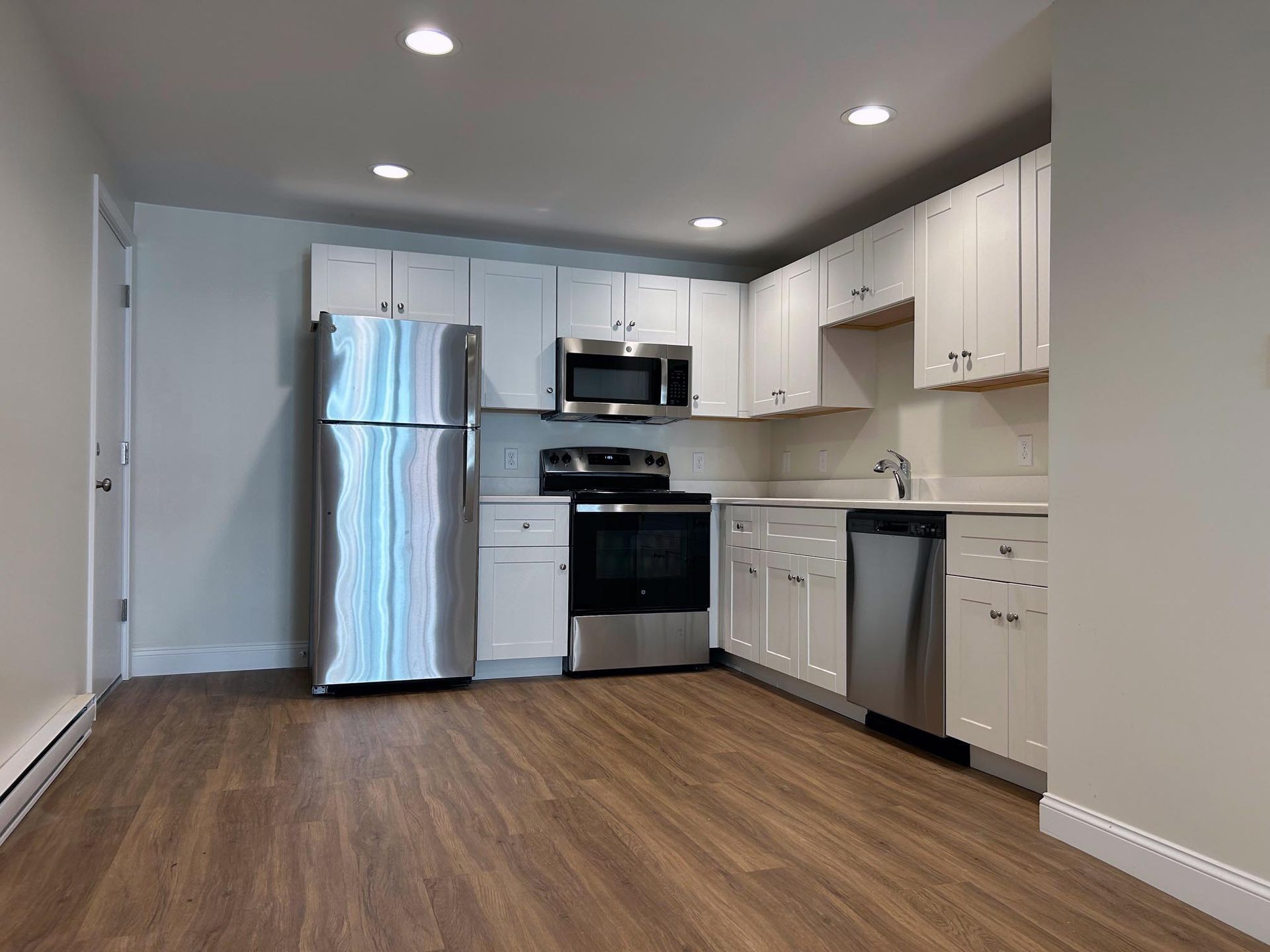 A kitchen with stainless steel appliances and white cabinets