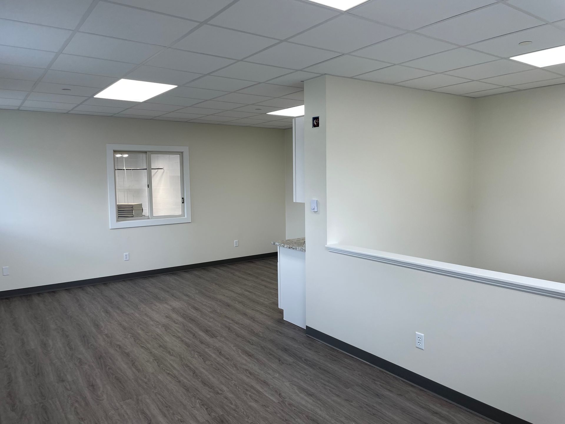 An empty room with hardwood floors and white walls