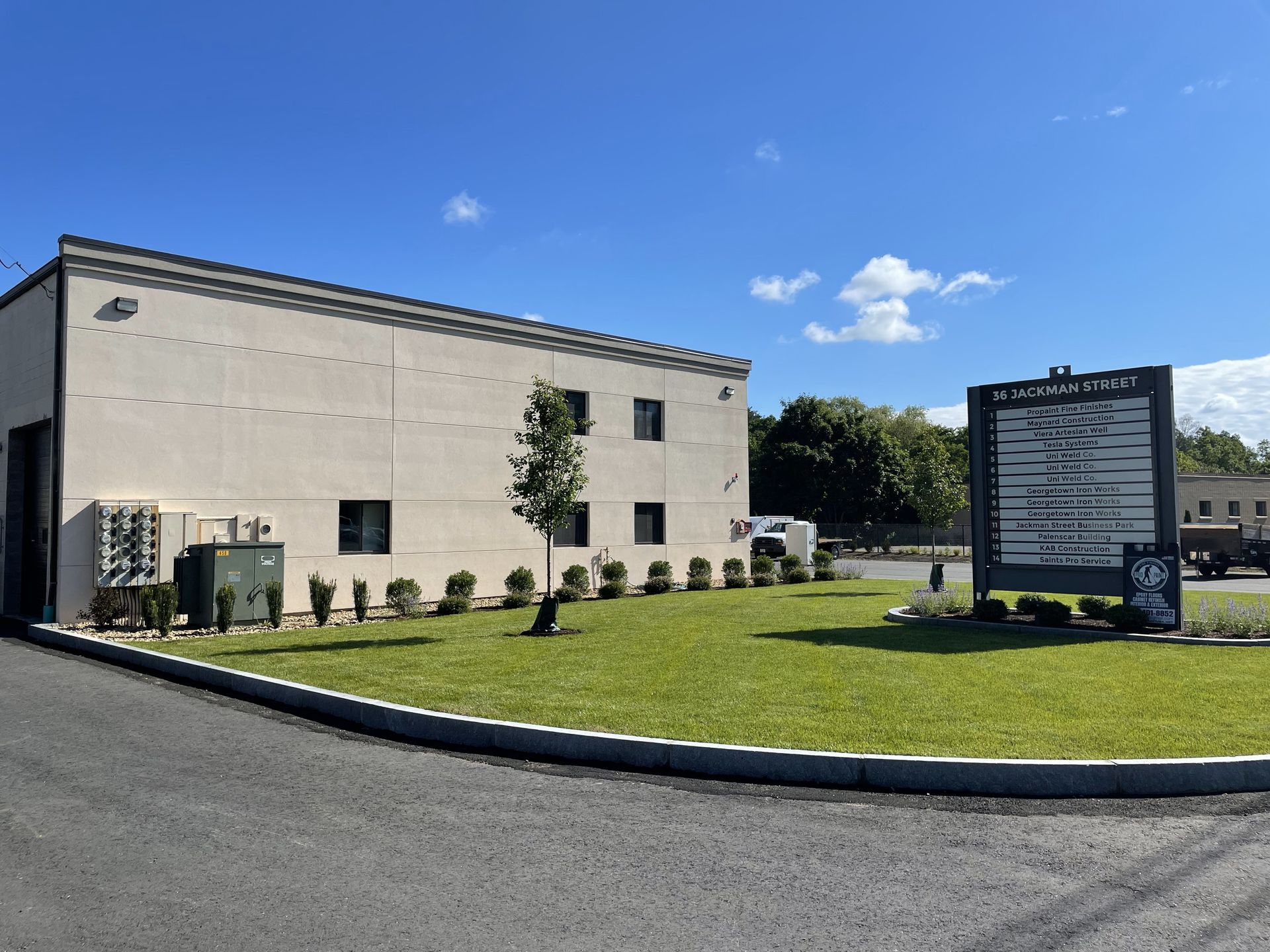 A large white building with a sign in front of it.