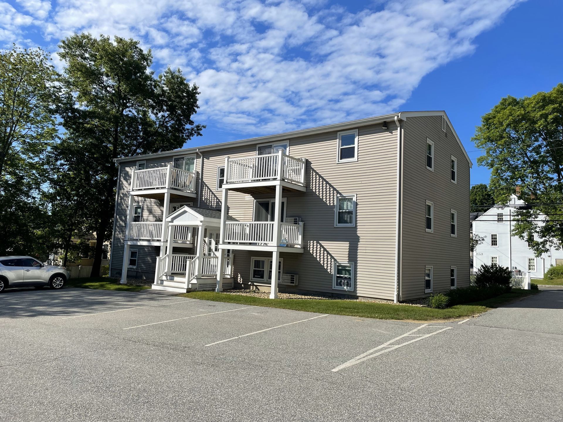 A large apartment building with a parking lot in front of it