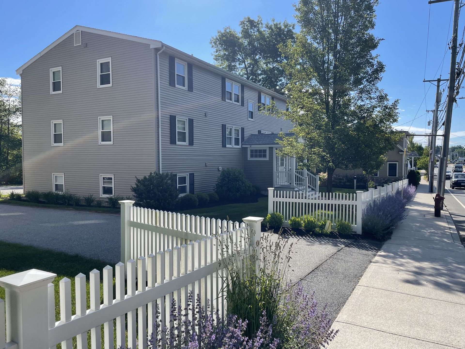 A white picket fence is in front of a building