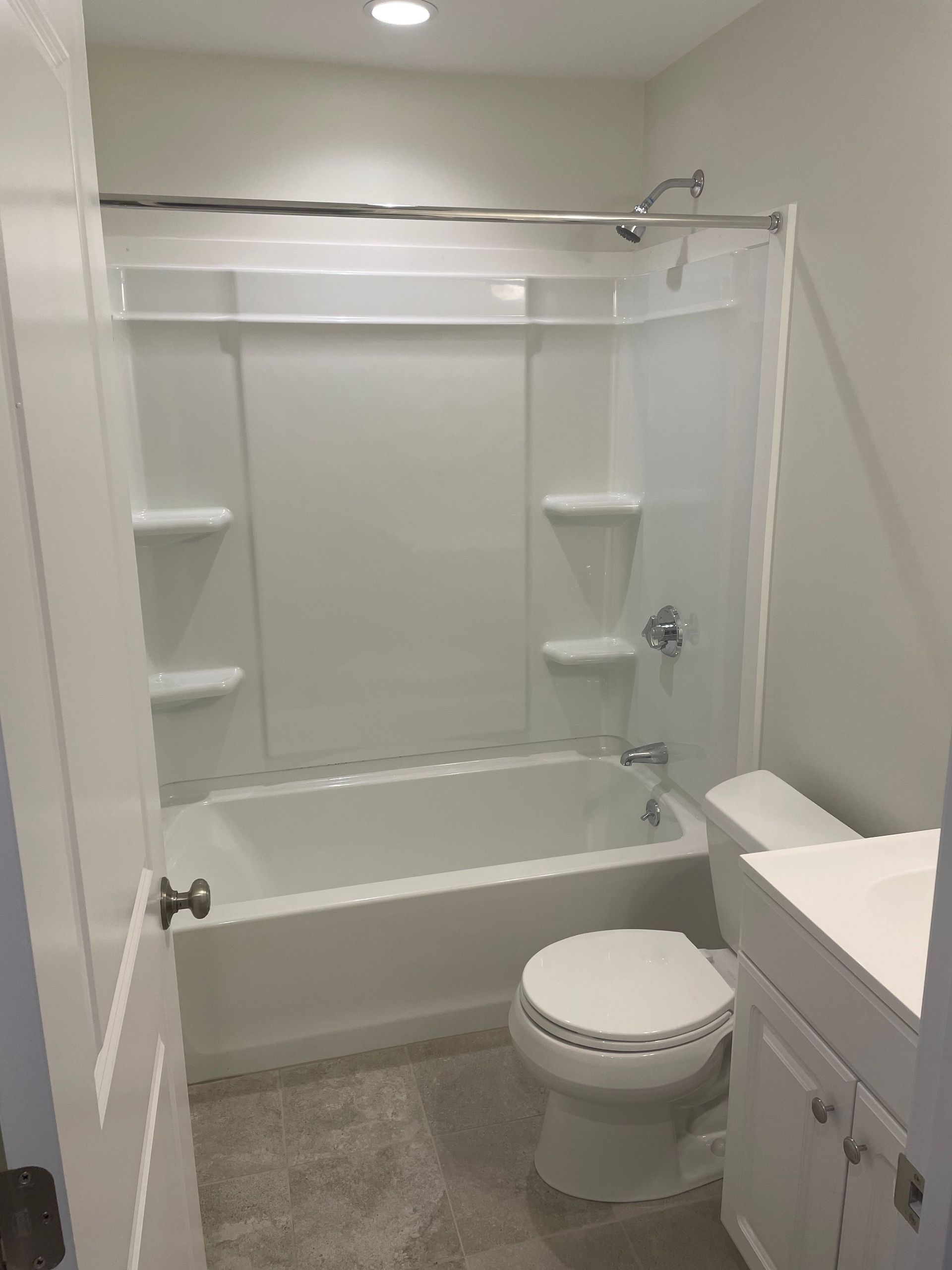 A bathroom with a tub , toilet , sink and shower.