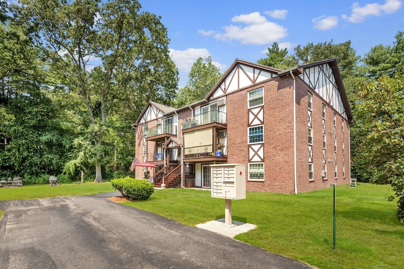 A large brick apartment building with a mailbox in front of it.