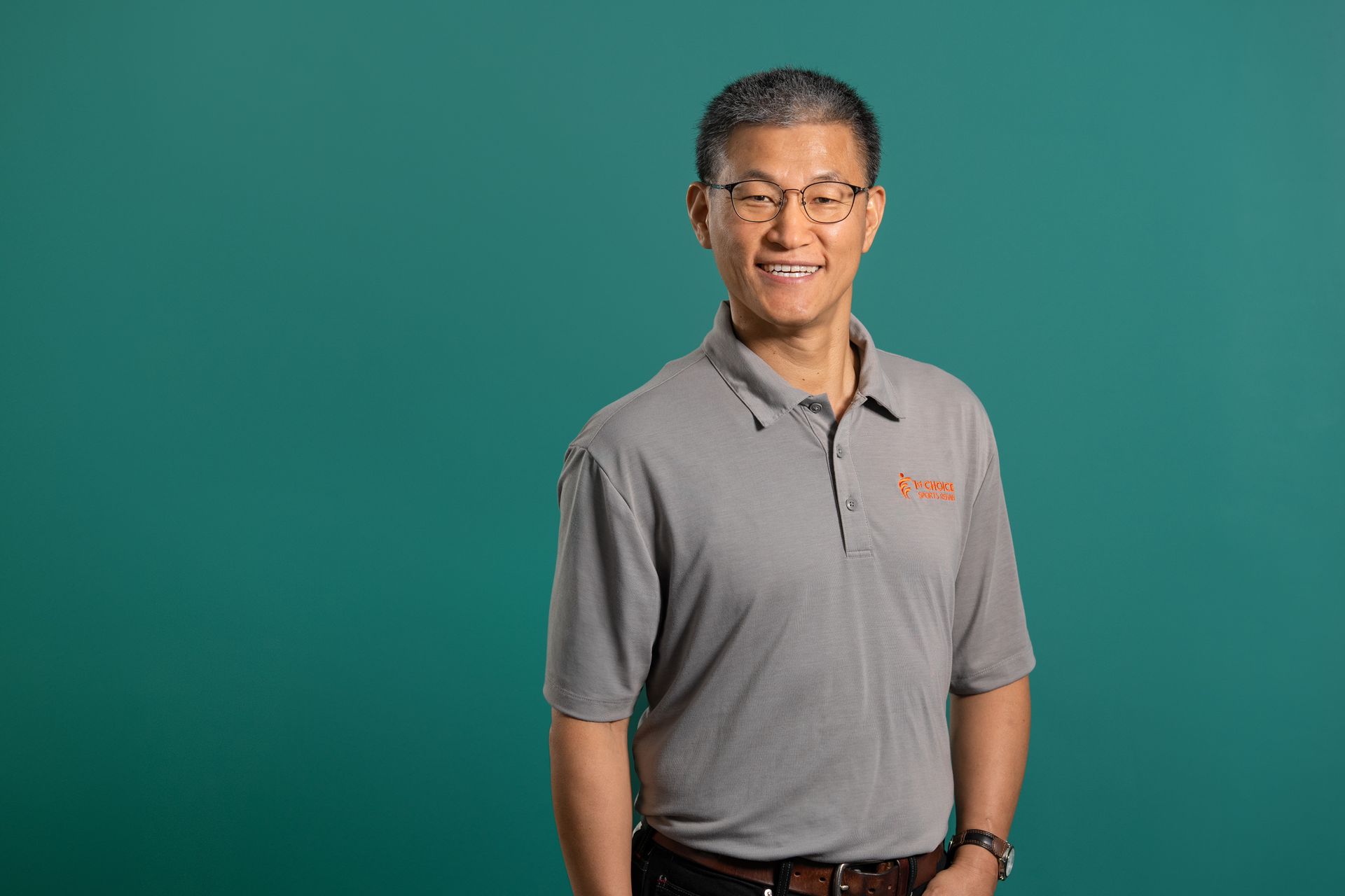 A man wearing glasses and a black shirt with a yellow logo on it