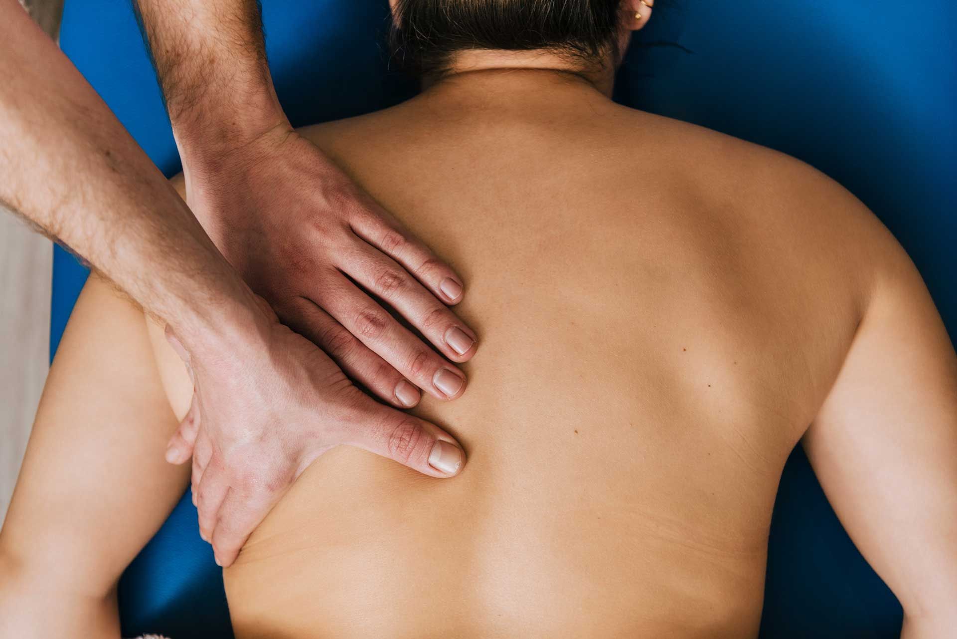 Massage therapist's hands on person's back during session.] 