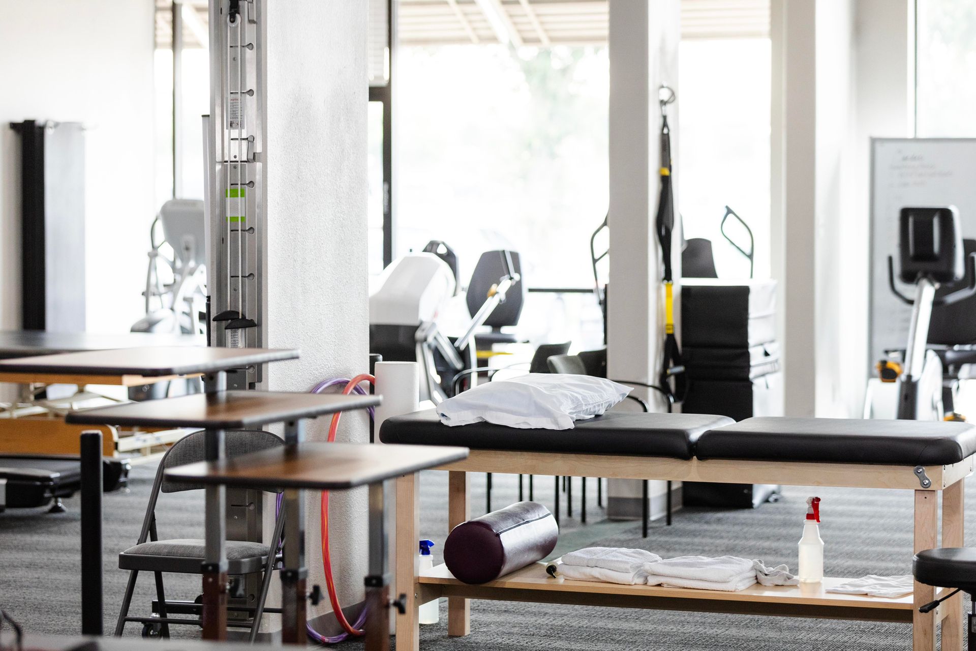 Physical therapy room with exercise equipment and treatment tables.