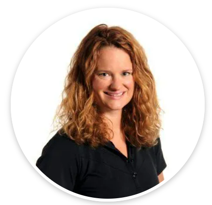 A woman with red hair is wearing a black shirt and smiling.