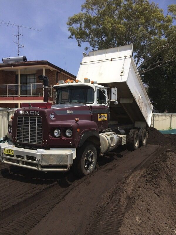 Maroon Dump Truck Disposing Dirt — Elmac Plant Hire In Taree