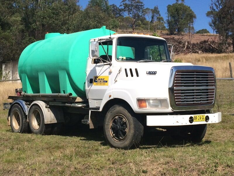 Water Truck with Aqua Tank in Grass Field — Elmac Plant Hire In Taree