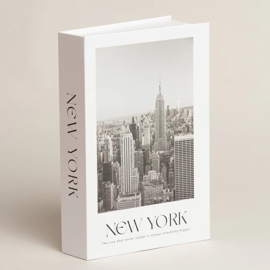 Una caja decorativa blanca para libros con una fotografía en blanco y negro del horizonte de la ciudad de Nueva York y las palabras 