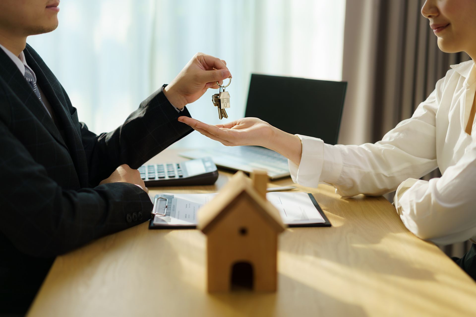 Real estate agent with house model and give keys to customer after signing contract - Stayton, OR - Stayton Law