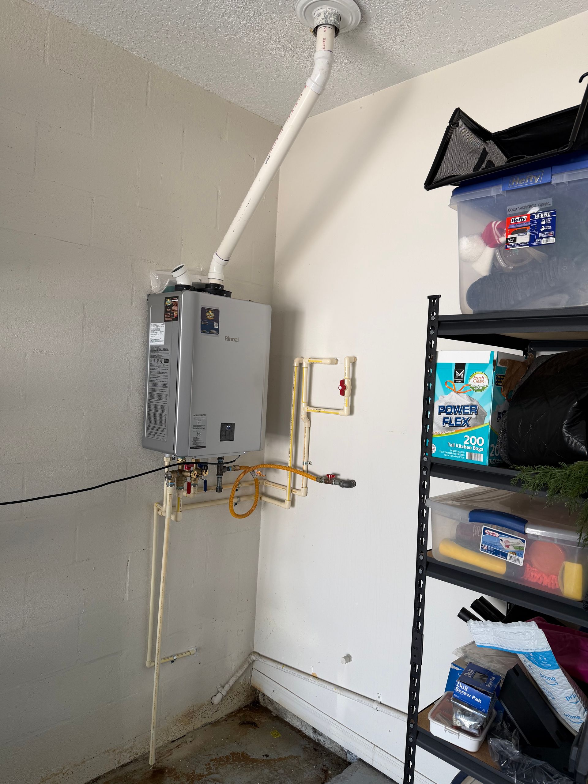 Plumbing tools on top of a water heater with pipes and valves.