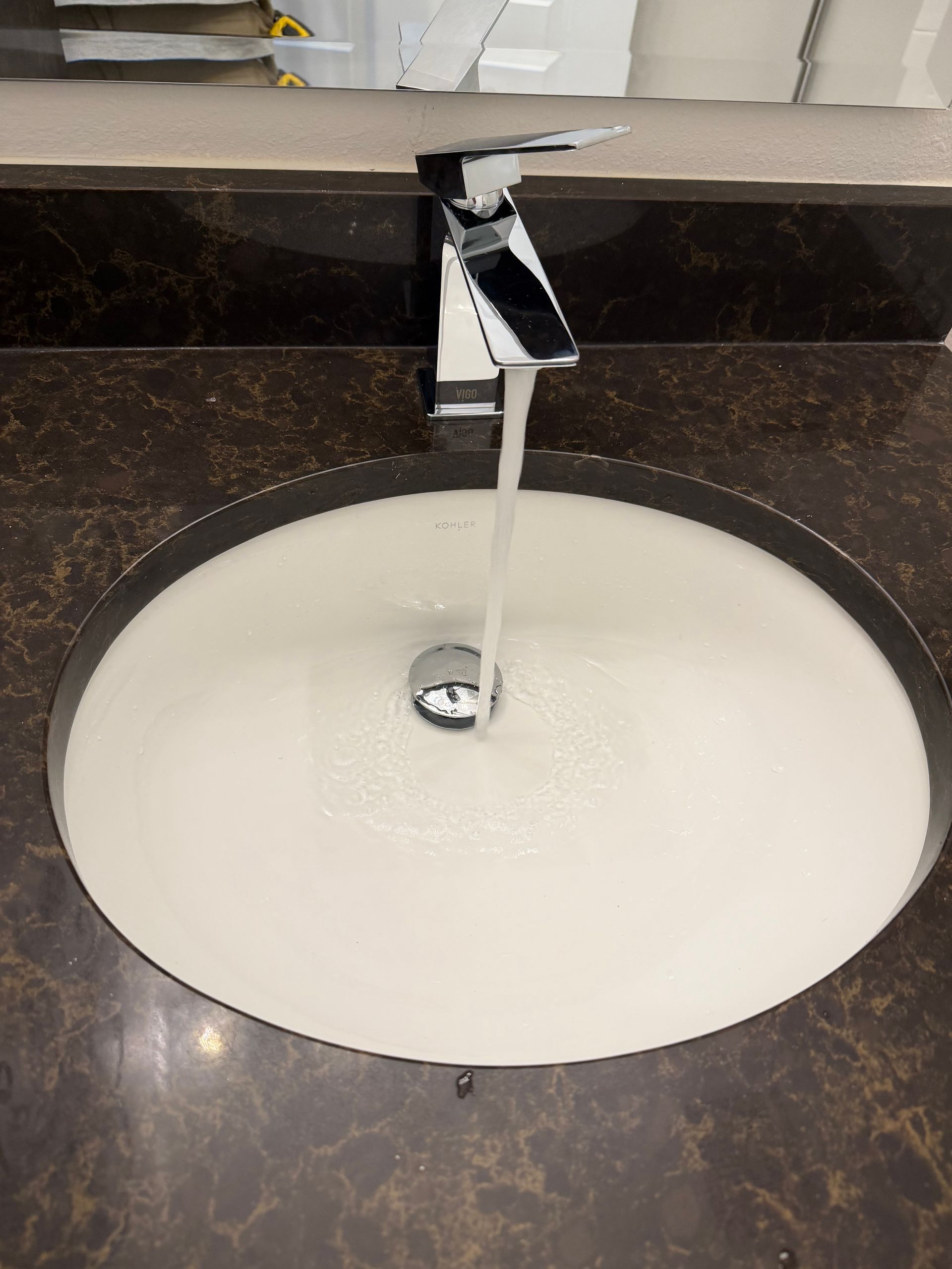 Plumber under a sink, examining pipes with a clipboard, flashlight, and power drill. Plumber under a sink, examining pipes with a clipboard, flashlight, and power drill.