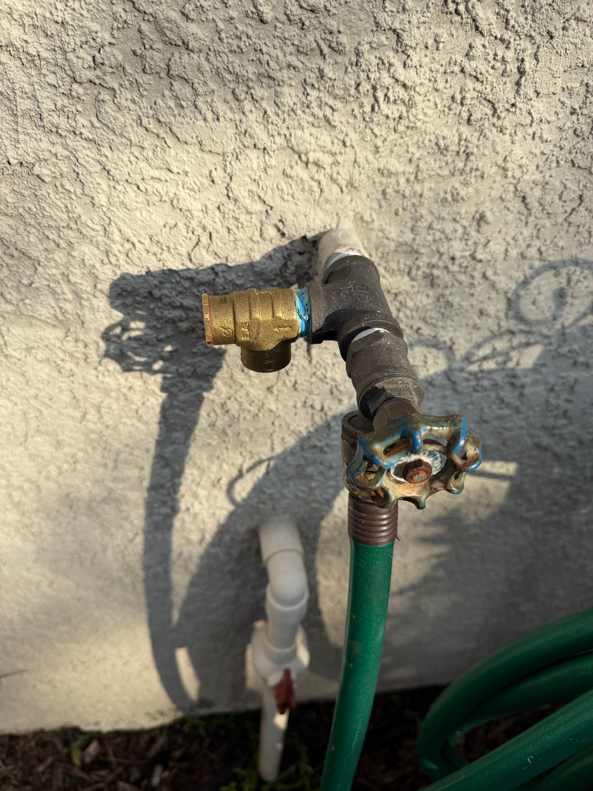 Plumber working under a kitchen sink, tools nearby. Plumber working under a kitchen sink, tools nearby.