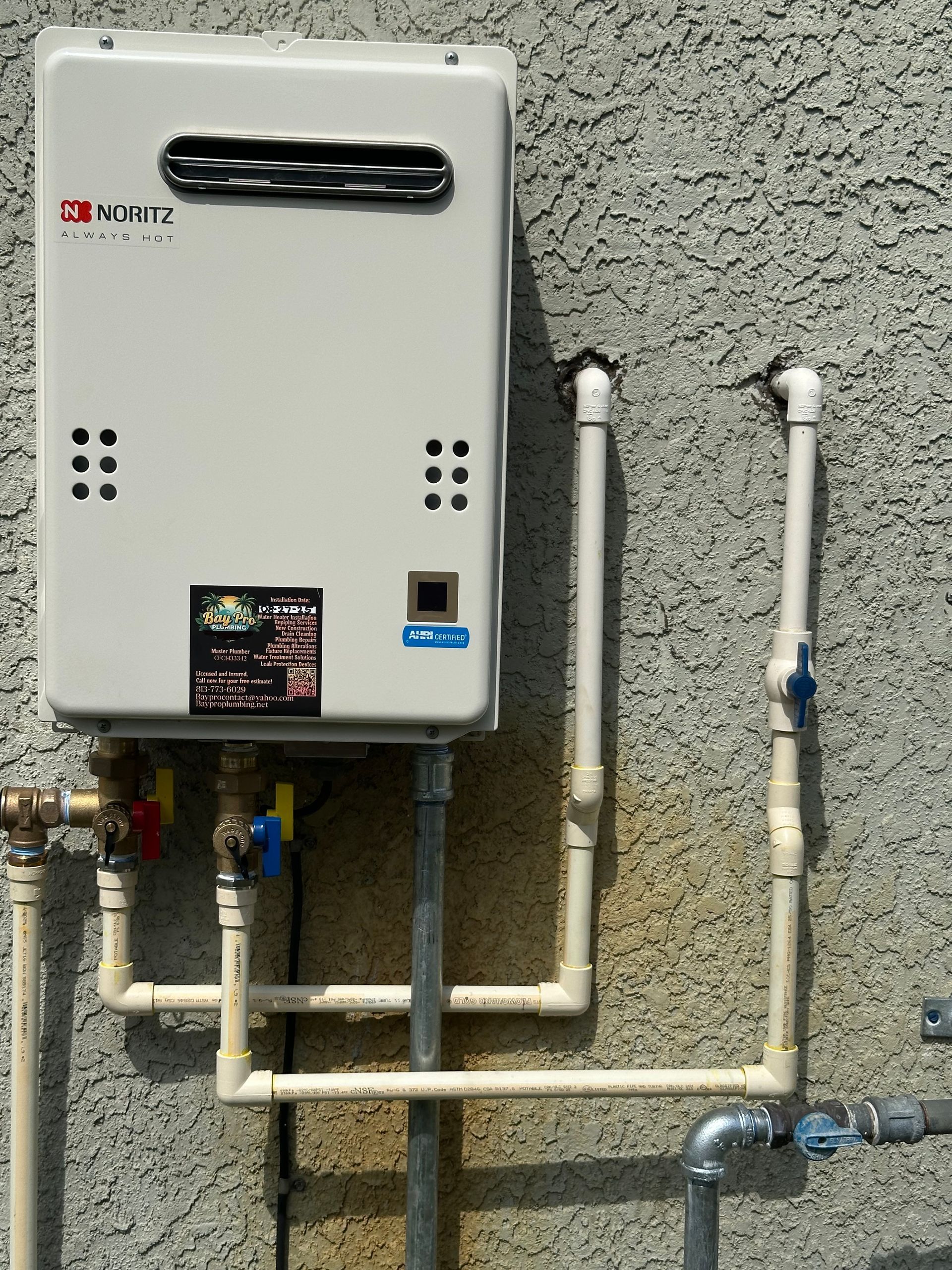 Person using a screwdriver to work on a water heater.