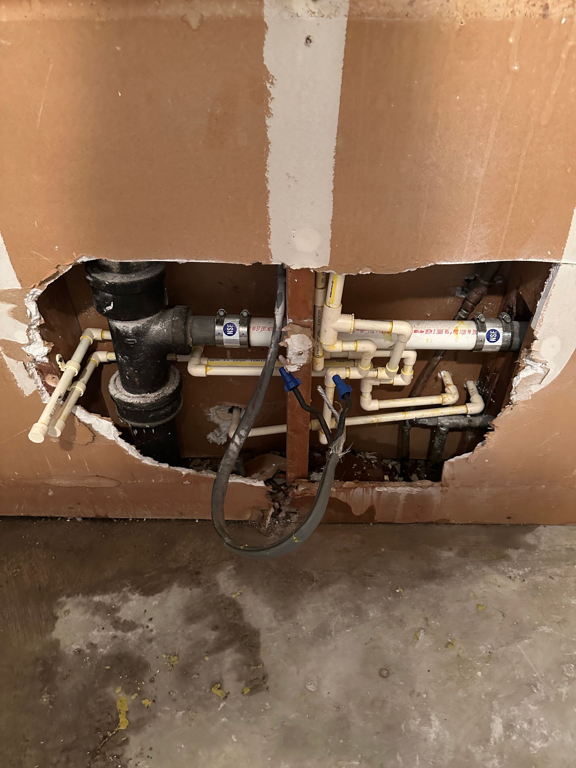 Plumber using pliers on a water pump. Red and blue valves, white pipes, and gauges visible. Plumber using pliers on a water pump. Red and blue valves, white pipes, and gauges visible.